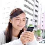 スマホを持って笑う女性