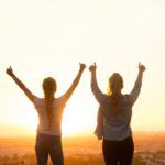 2人の女性の後ろ姿と夕日