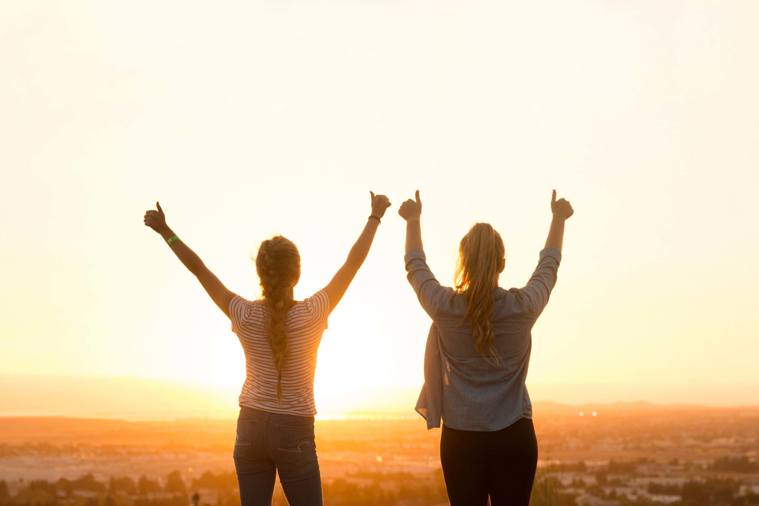 2人の女性の後ろ姿と夕日